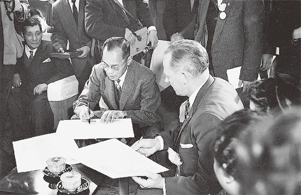 1959年11月17日、札幌にて盟約書にサインをする札幌市長とポートランド市長